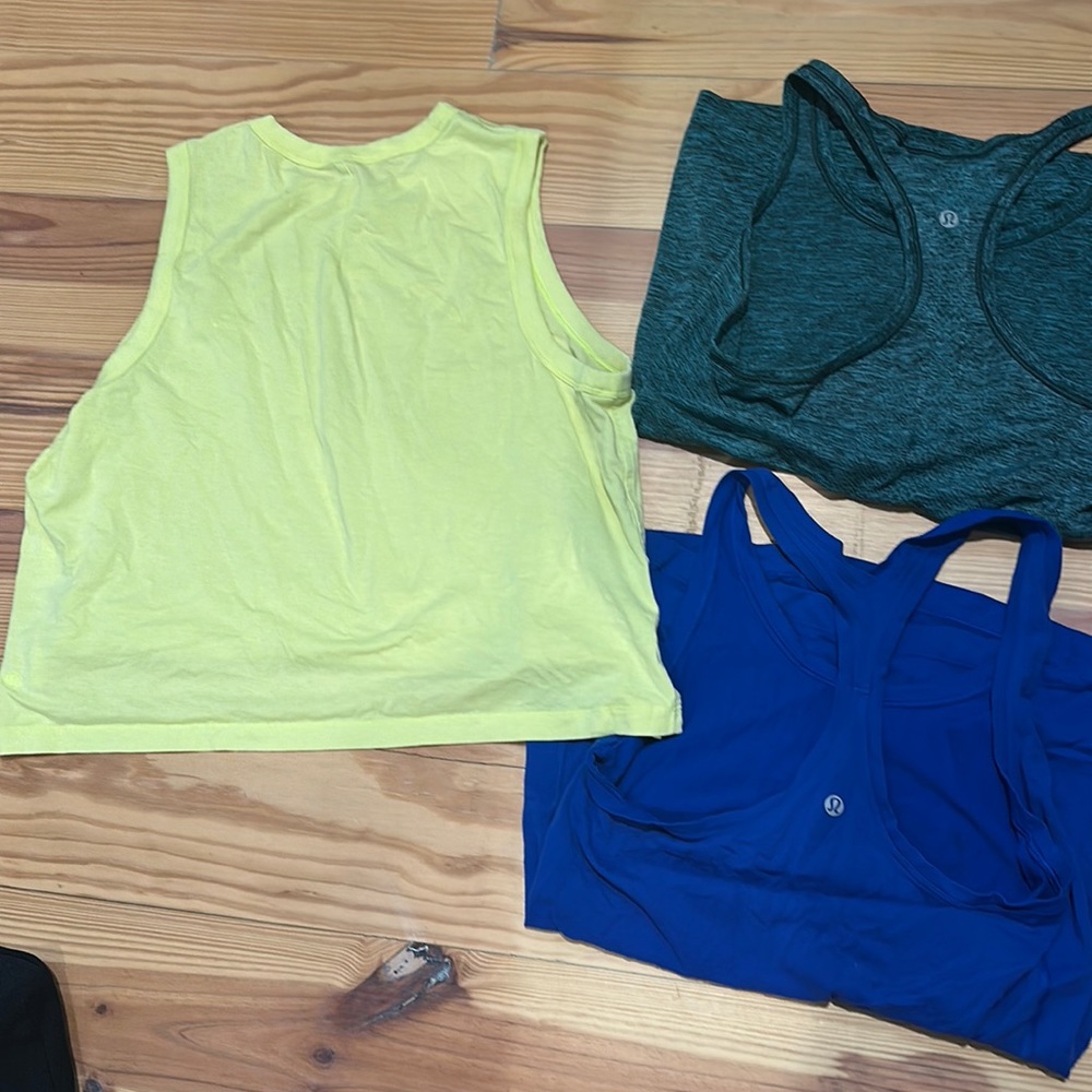 Three Lululemon shirts. Two tanks and one crop top.